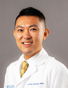 Alexandre Chan, PharmD, pictured in his white coat, is leading a clinical trial to test an ALS drug for cancer-related chemo brain.